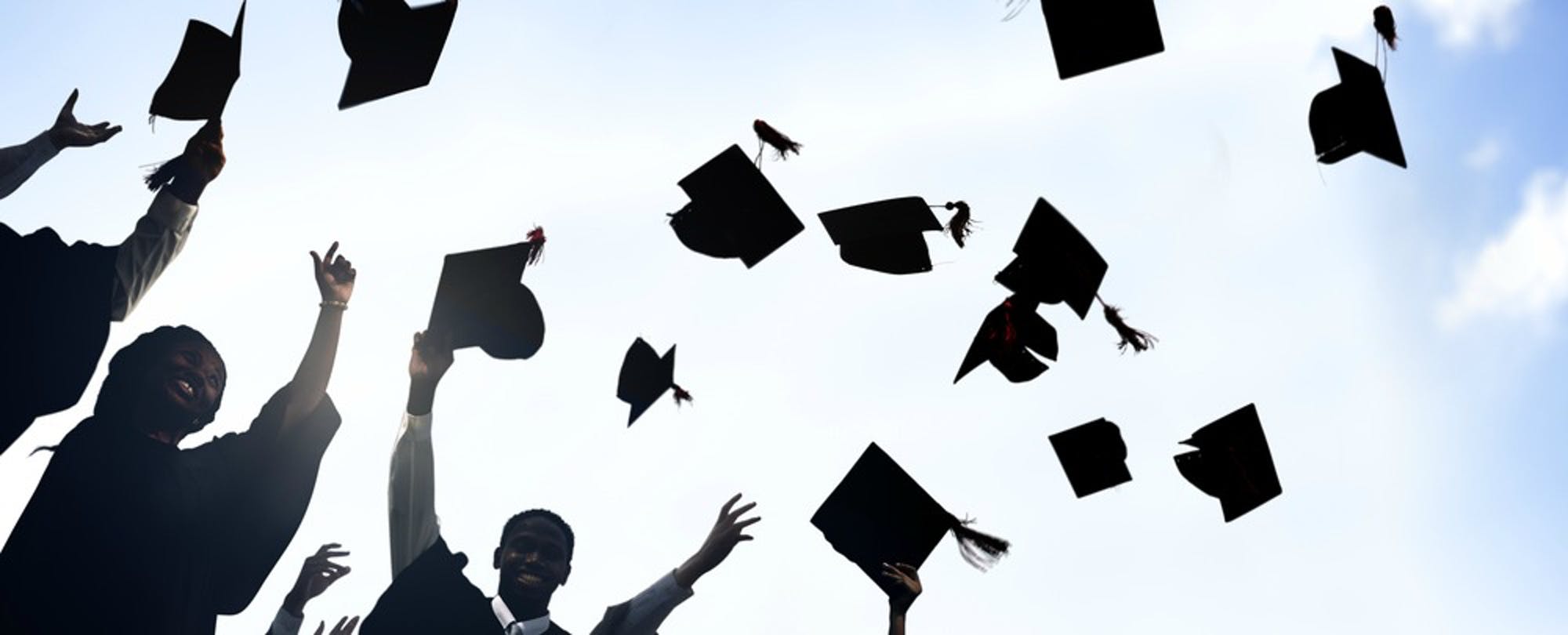 graduates throwing caps in celebration